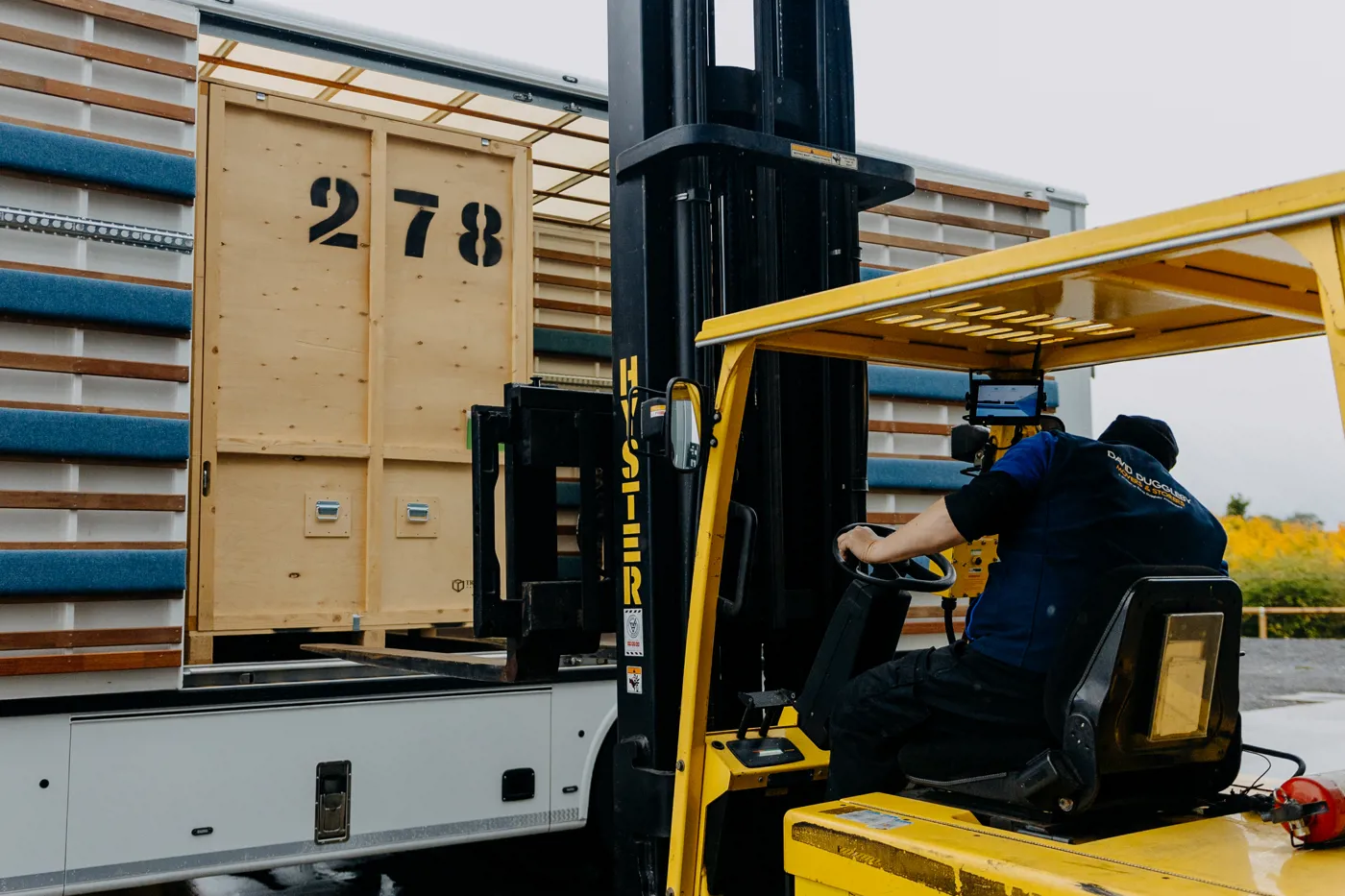 Forklift loading a timber storage container onto a lorry