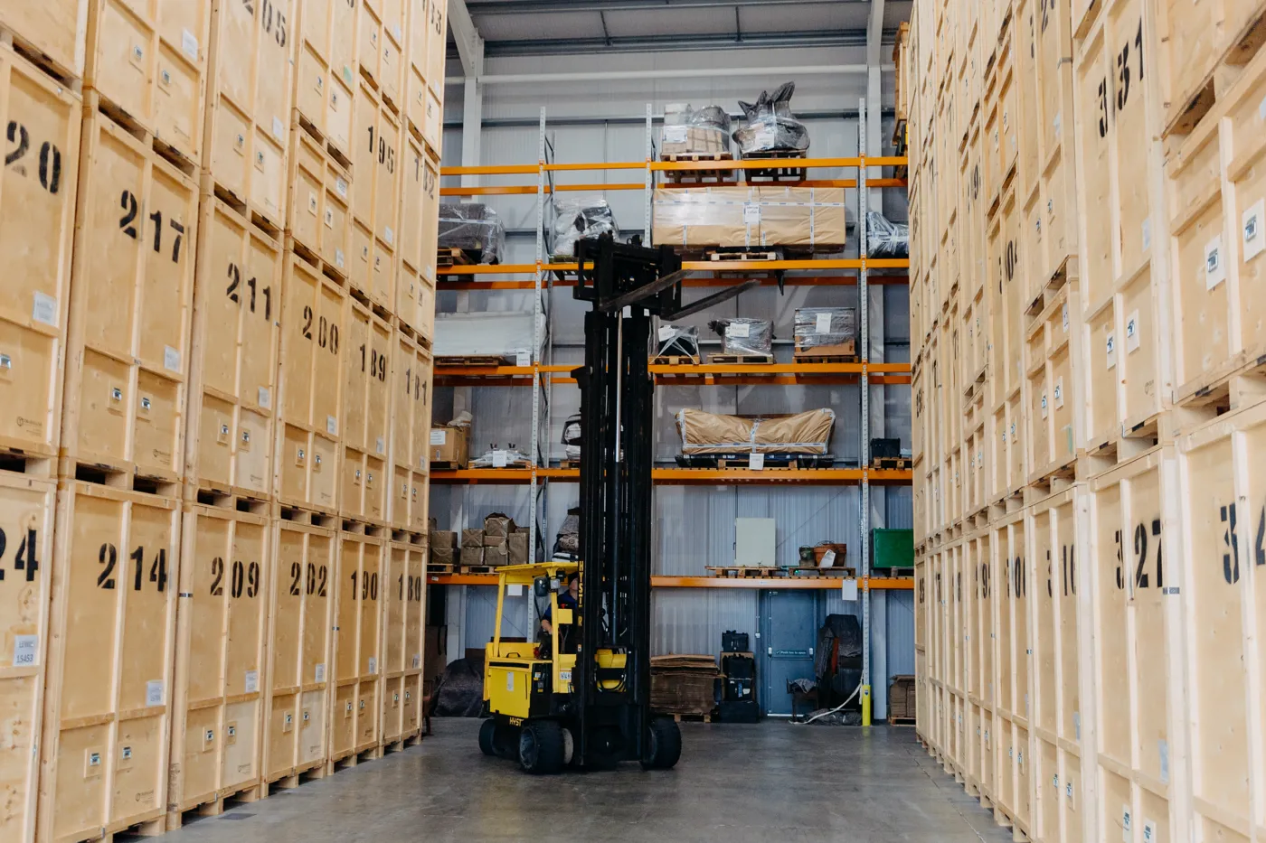 Forklift moving timber storage containers inside the warehouse